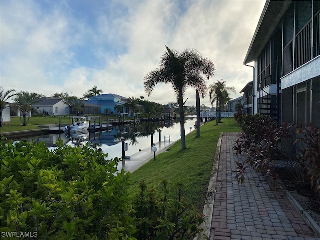 view of nearby features featuring a lawn, a water view, and a dock