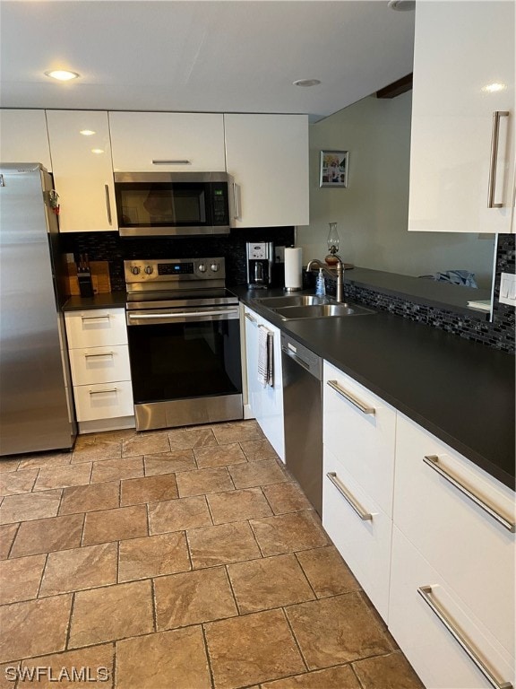 kitchen with stainless steel appliances, light tile flooring, white cabinets, and sink