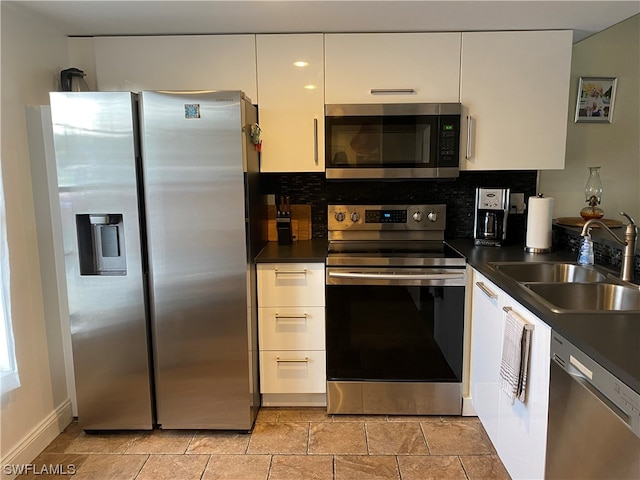 kitchen featuring white cabinets, light tile floors, appliances with stainless steel finishes, and sink