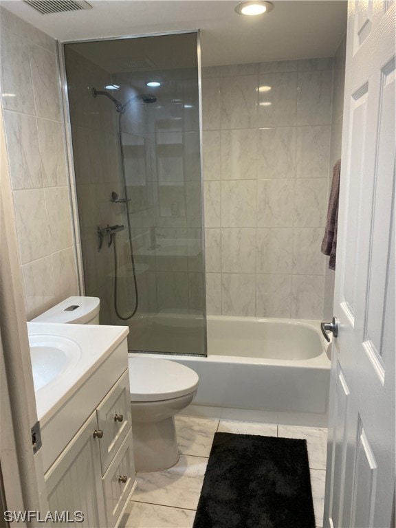 full bathroom featuring vanity, tile floors, toilet, and tiled shower / bath