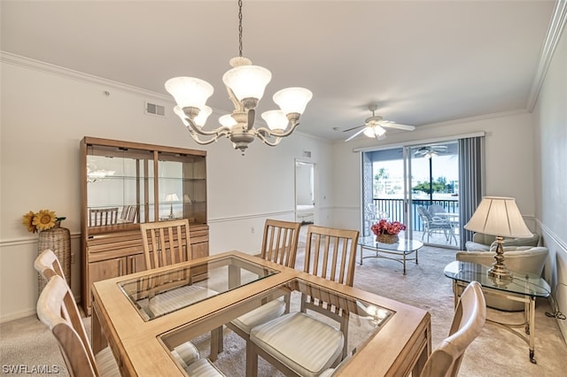 dining room with ornamental molding, ceiling fan with notable chandelier, and light colored carpet