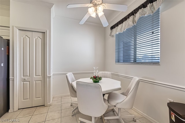 dining room featuring crown molding, ceiling fan, and light tile floors