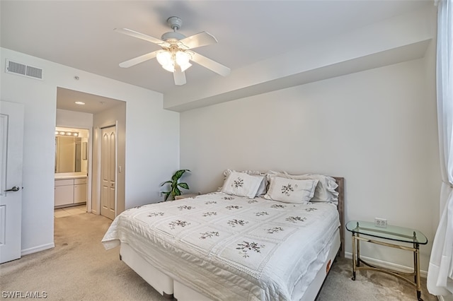 bedroom featuring ceiling fan, connected bathroom, and light carpet