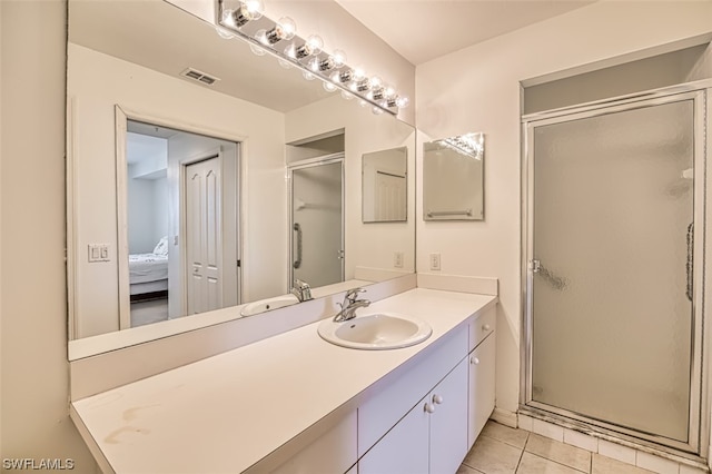 bathroom featuring tile floors, vanity, and an enclosed shower