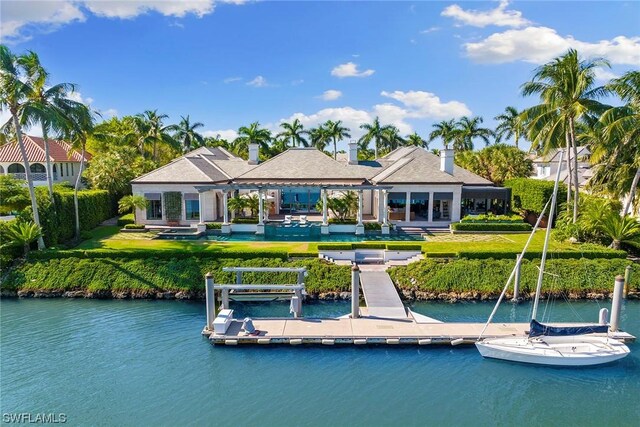 back of house featuring a water view and a yard