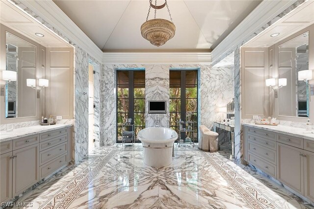 bathroom with ornamental molding, vanity, and a tub