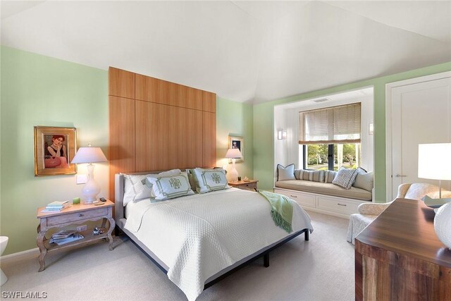 bedroom featuring vaulted ceiling and light colored carpet