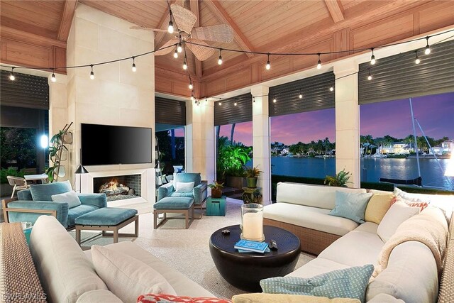 view of patio with ceiling fan and an outdoor living space with a fireplace