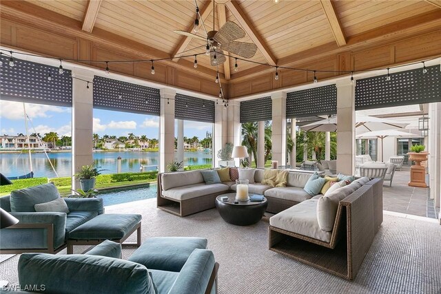 sunroom with lofted ceiling with beams, a water view, wood ceiling, and ceiling fan