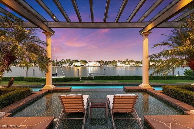 pool at dusk featuring a water view and a pergola