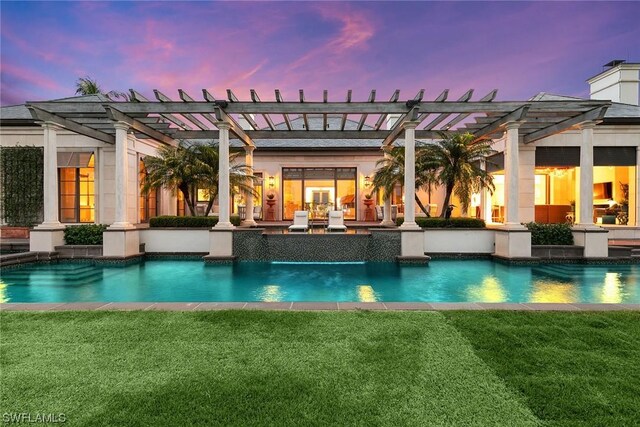 pool at dusk with a lawn and a patio area