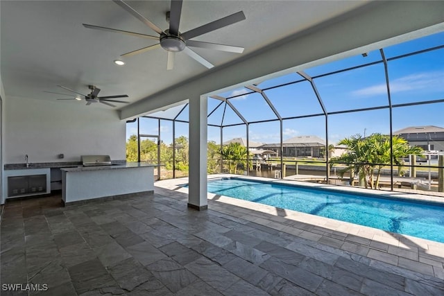 view of pool with sink, exterior kitchen, a lanai, grilling area, and a patio area