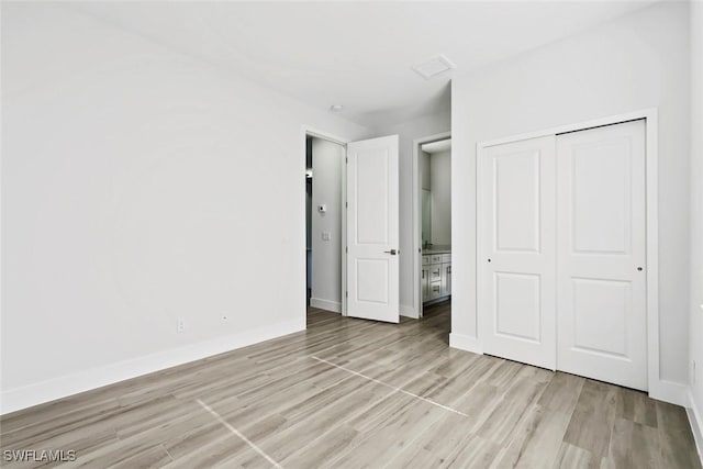 unfurnished bedroom featuring light hardwood / wood-style flooring and a closet