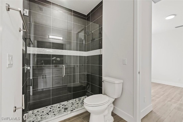 bathroom with a shower with shower door and toilet