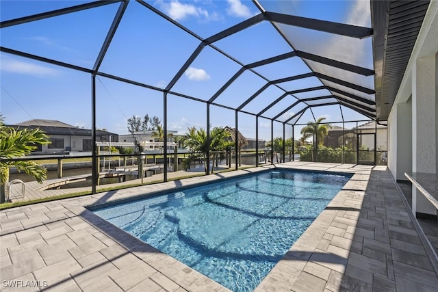 view of swimming pool featuring a patio, a boat dock, and glass enclosure