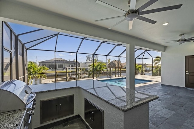 view of patio with an outdoor kitchen, area for grilling, a lanai, an outdoor bar, and ceiling fan