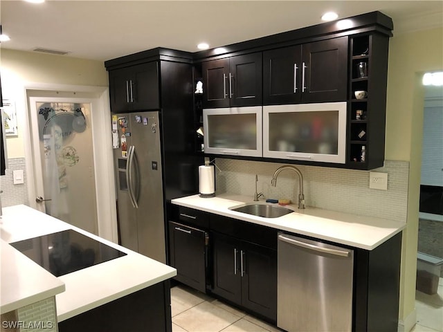 kitchen featuring appliances with stainless steel finishes, tasteful backsplash, light tile patterned floors, and sink