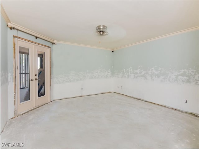 spare room featuring crown molding, concrete floors, and french doors