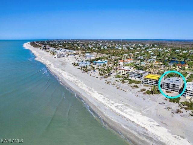 bird's eye view featuring a water view and a beach view