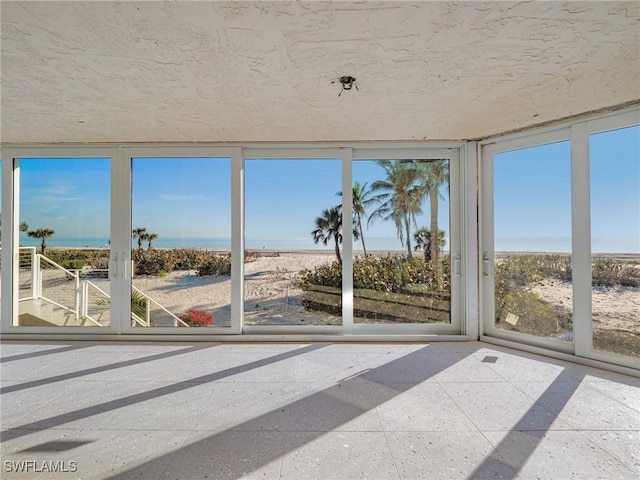 unfurnished sunroom with a water view