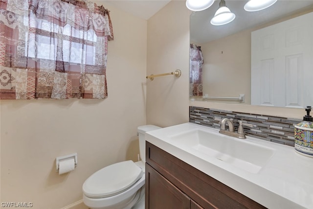 bathroom featuring tasteful backsplash, vanity, and toilet