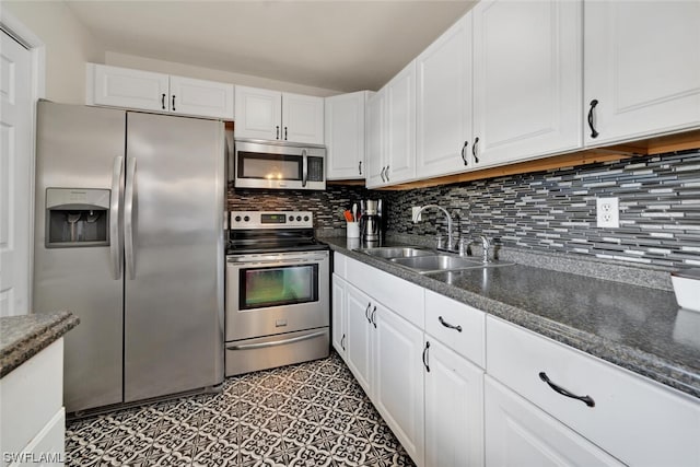 kitchen featuring appliances with stainless steel finishes, backsplash, white cabinetry, and sink