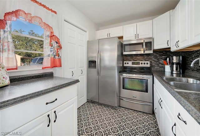 kitchen featuring tasteful backsplash, white cabinetry, sink, and appliances with stainless steel finishes