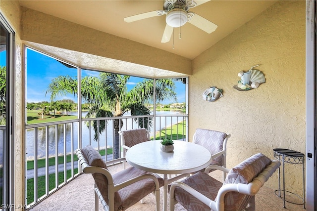 sunroom / solarium featuring lofted ceiling, a water view, ceiling fan, and a wealth of natural light