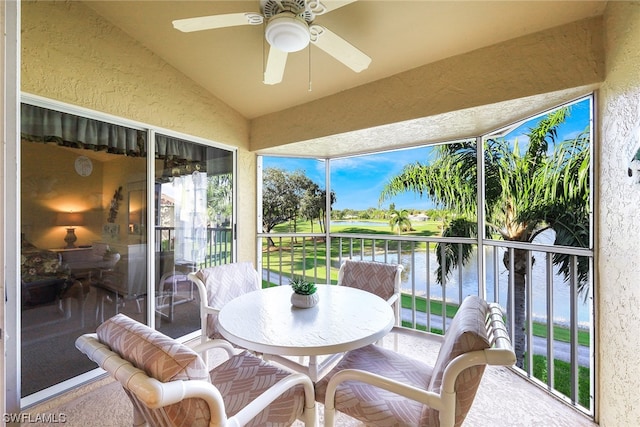 sunroom / solarium with lofted ceiling, a water view, and ceiling fan