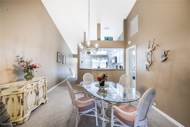 dining space with an inviting chandelier, light carpet, and high vaulted ceiling