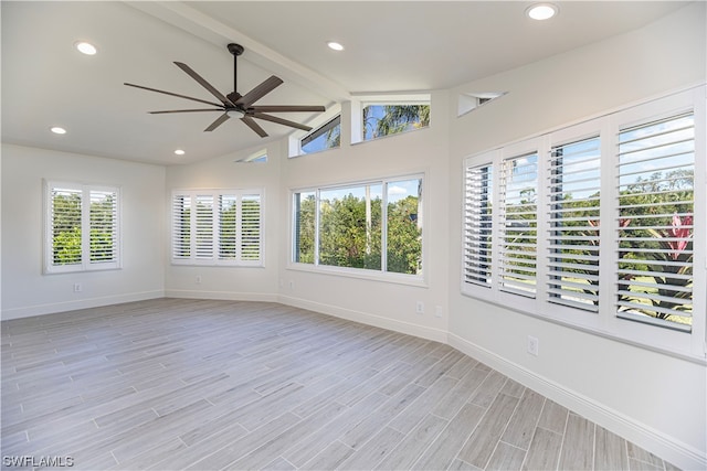 empty room featuring light hardwood / wood-style flooring, vaulted ceiling with beams, and ceiling fan