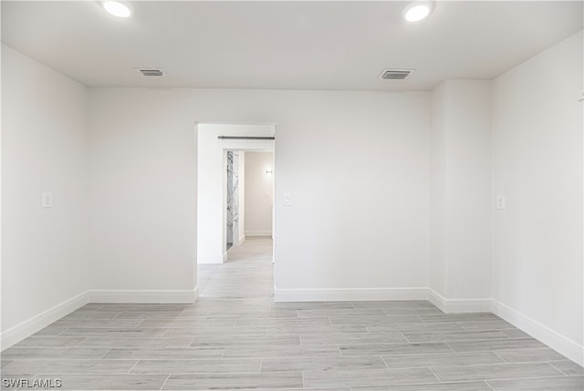 unfurnished room featuring a barn door