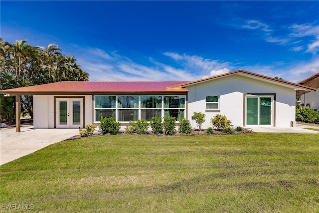 back of property with a lawn and a patio