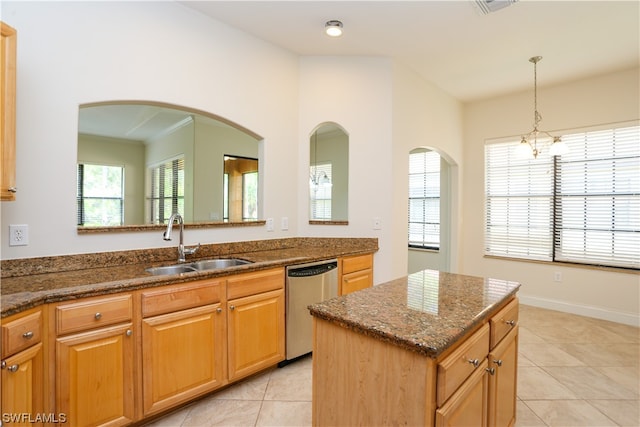 kitchen with sink, light tile floors, dark stone counters, dishwasher, and a kitchen island