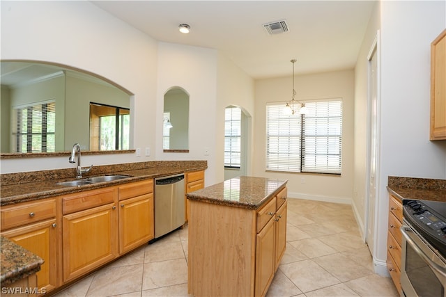 kitchen with a chandelier, light tile floors, a kitchen island, appliances with stainless steel finishes, and dark stone countertops