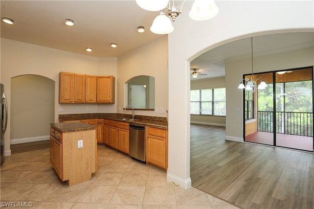 kitchen with hanging light fixtures, sink, light tile floors, stainless steel dishwasher, and a kitchen island