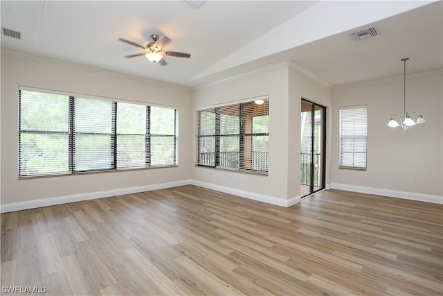 empty room featuring plenty of natural light, light wood-type flooring, and ceiling fan with notable chandelier