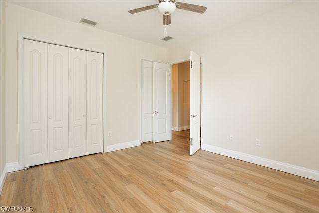 unfurnished bedroom featuring a closet, light hardwood / wood-style floors, and ceiling fan