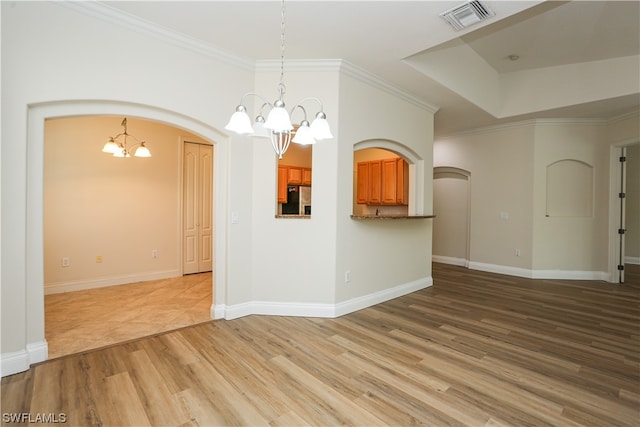 empty room with a notable chandelier and hardwood / wood-style flooring