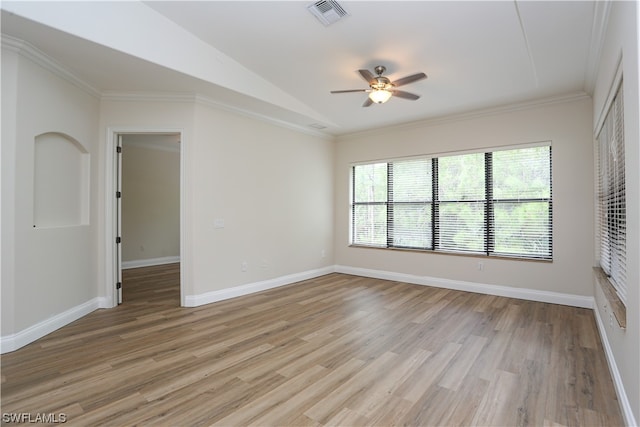 spare room with vaulted ceiling, ceiling fan, light wood-type flooring, and crown molding