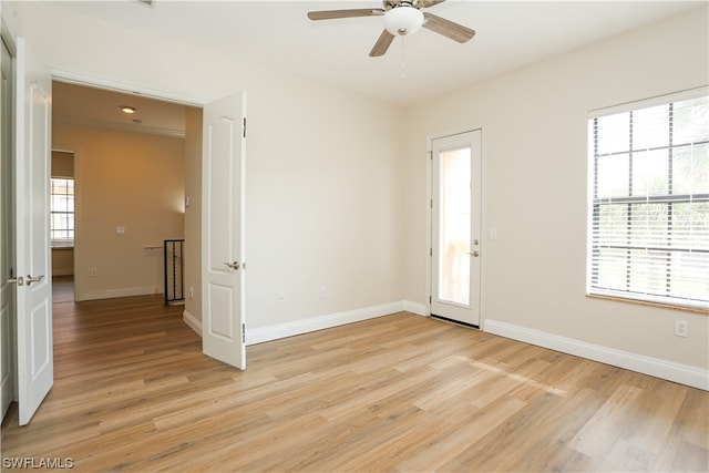 empty room with ceiling fan and light hardwood / wood-style flooring