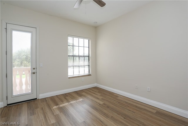 unfurnished room with plenty of natural light, ceiling fan, and dark hardwood / wood-style floors