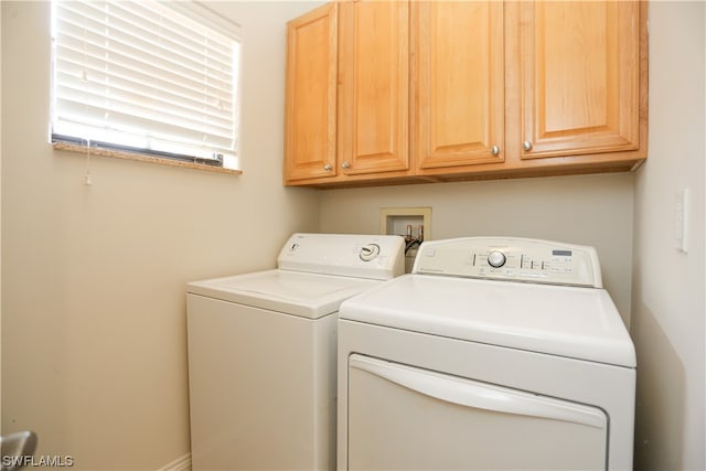 washroom featuring washer hookup, cabinets, and washing machine and dryer