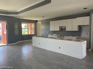 kitchen featuring dark tile floors, white cabinets, and a center island