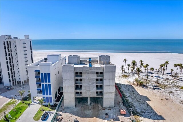 drone / aerial view with a water view and a beach view