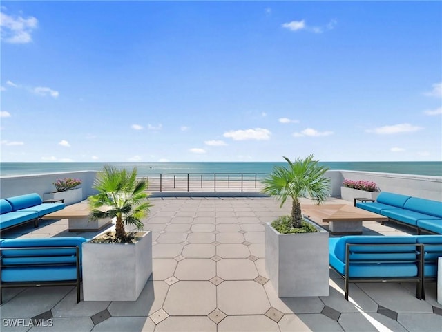 view of patio / terrace featuring a view of the beach, a water view, and outdoor lounge area