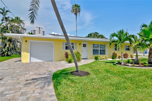 ranch-style house featuring a garage and a front lawn