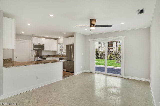 kitchen featuring white cabinetry, stone counters, ceiling fan, kitchen peninsula, and appliances with stainless steel finishes