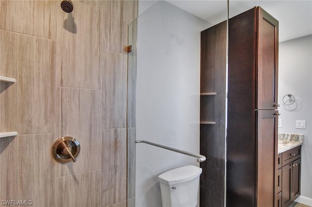 bathroom with walk in shower, vanity, and toilet