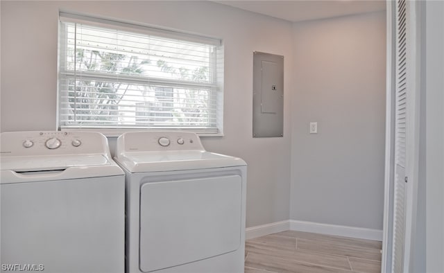 clothes washing area featuring independent washer and dryer, electric panel, and light hardwood / wood-style floors